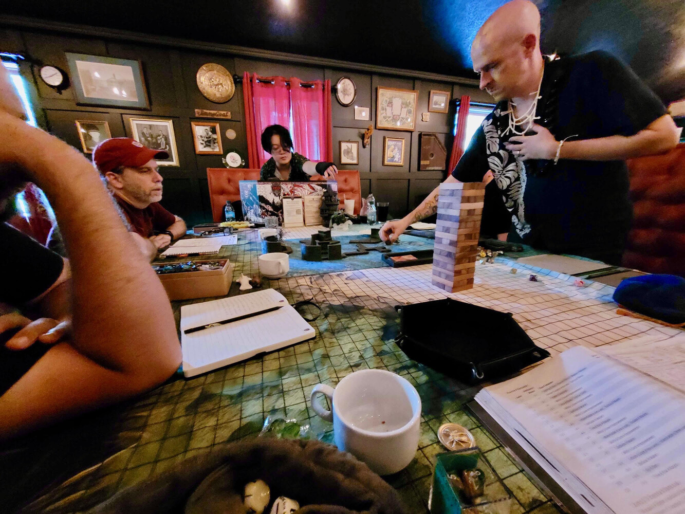 A Dungeons and Dragons game in progress around a battle-map table in a wood-paneled room