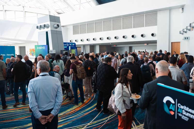 A crowded convention center lobby full of attendees between sponsor booths